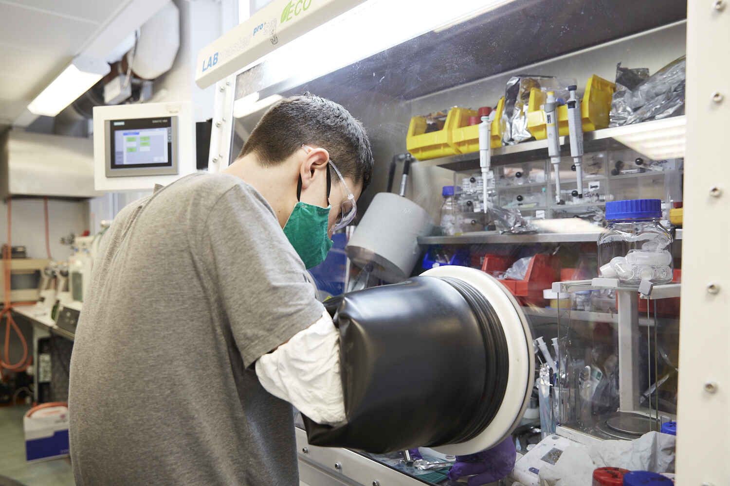 A doctoral candidate is mounting a battery prototype in an argon protective atmosphere.