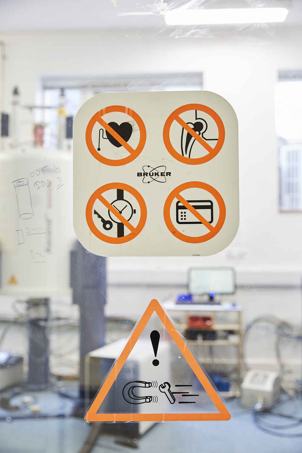 Warning signs on the door of the NMR laboratory. In the strong magnetic field of the NMR spectrometer, heart pace makers can stop functioning. Entrance with artificial joints is also forbidden. Particularly dangerous are metal objects attracted by the magnets, which could injure people and destroy the magnets. Credit cards could also lose the information they store magnetically.