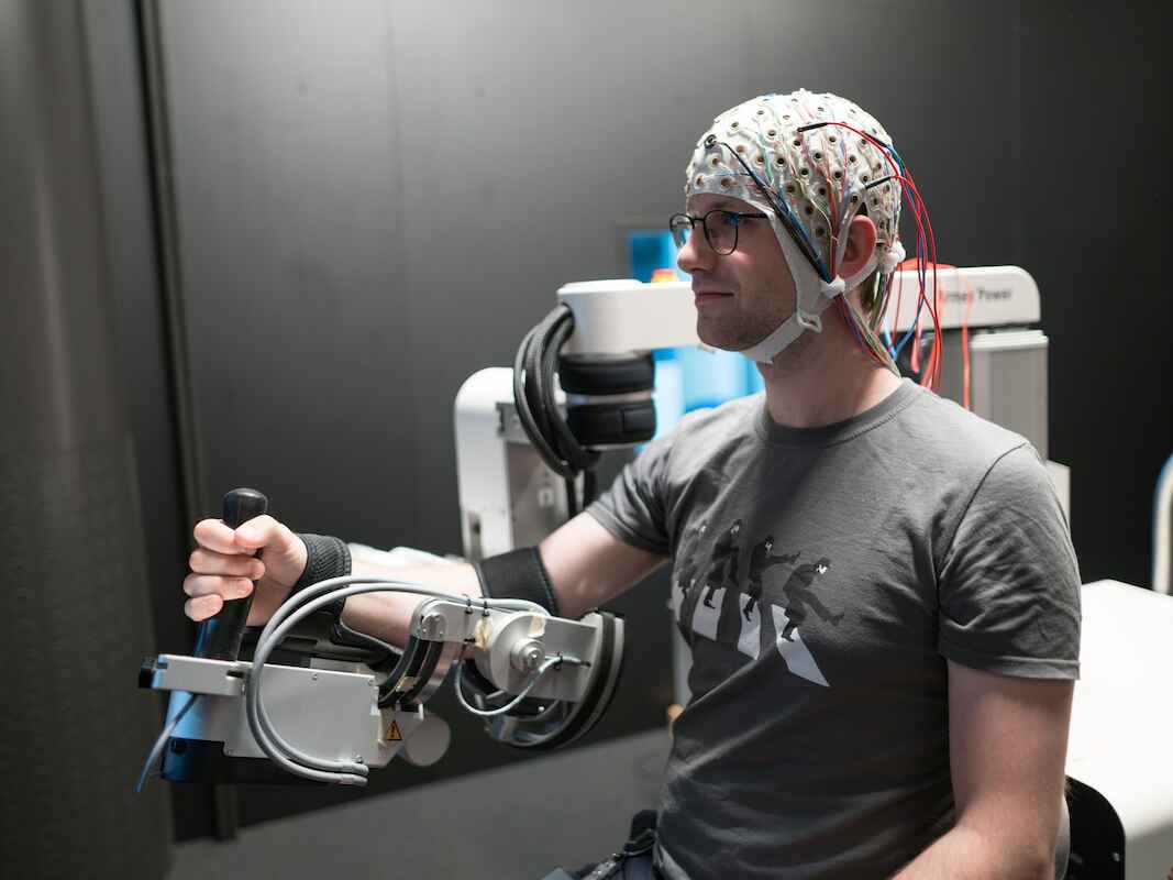 Simon Guist, Doktorand im MPI Tübingen, bringt einem künstlichen Arm bei, virtuelle Bälle zurückzuspielen.