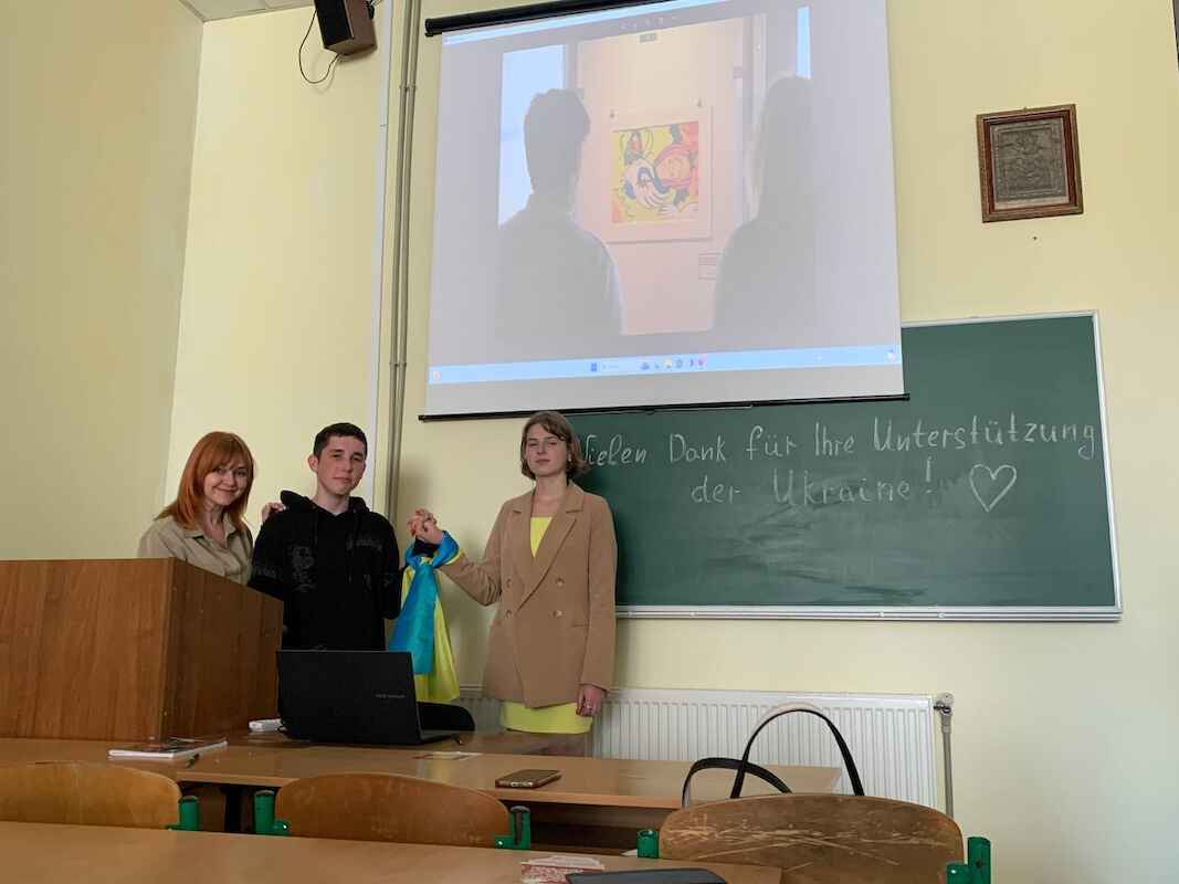 Iryna K. und ihre Schülerinnen und Schüler mit Fotos der Ausstellung